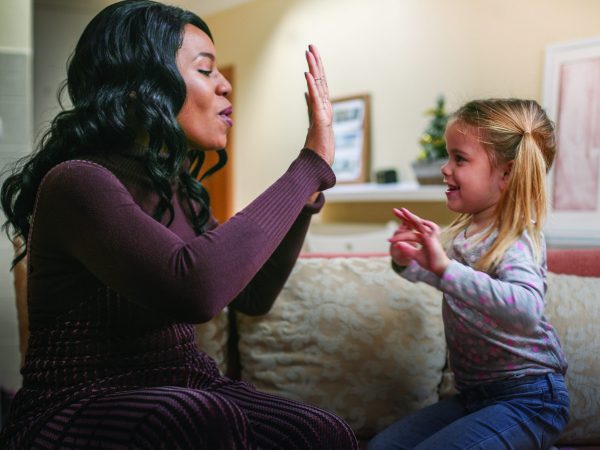 African American woman with child. African American woman playing with girl.